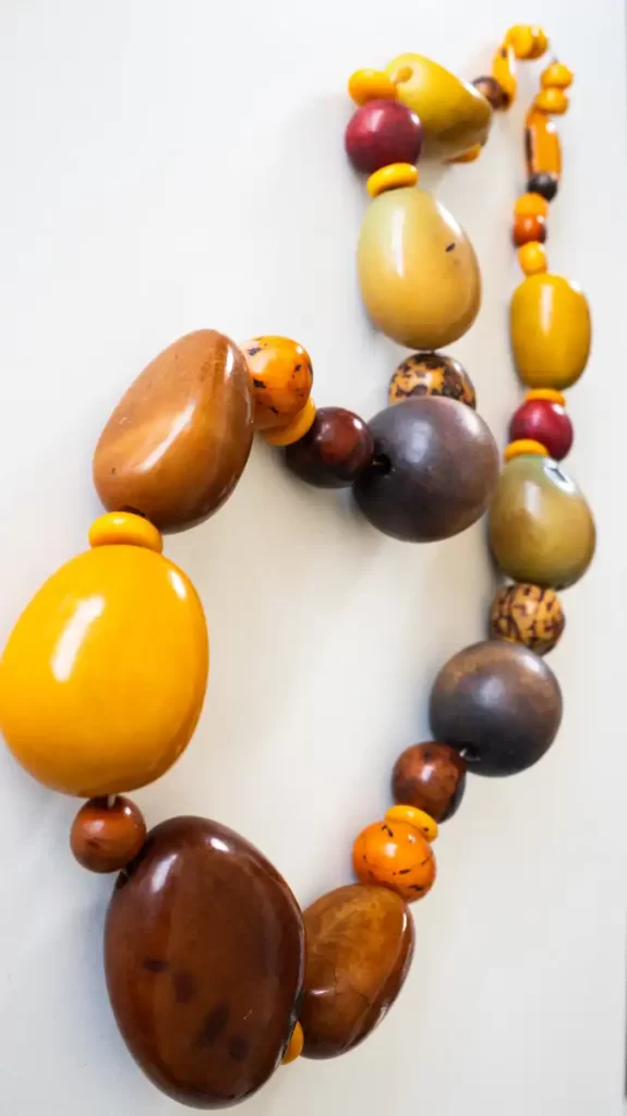 Collar de cuentas grandes en tonos terracota y amarillos con estilo rústico, inspirado en semillas de la naturaleza, elaborado artesanalmente por Amarandes, bisutería artesanal en Ecuador.