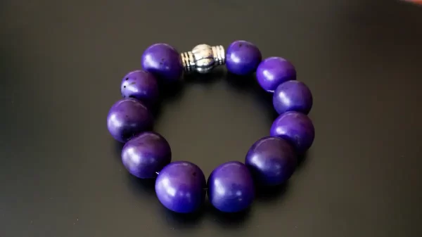 Pulsera artesanal con cuentas púrpuras brillantes, elaborada a mano por Amarandes, bisutería artesanal Ecuador.